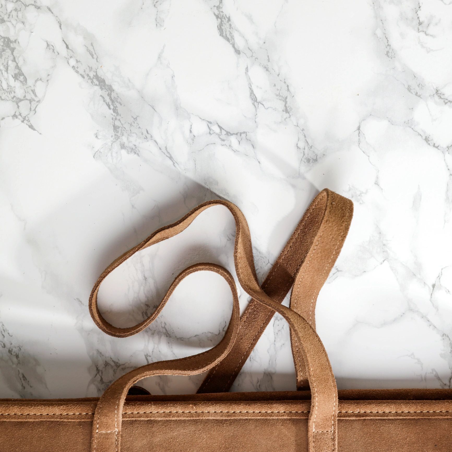 Structured leather tote bag photographed in a clean, minimalist editorial style